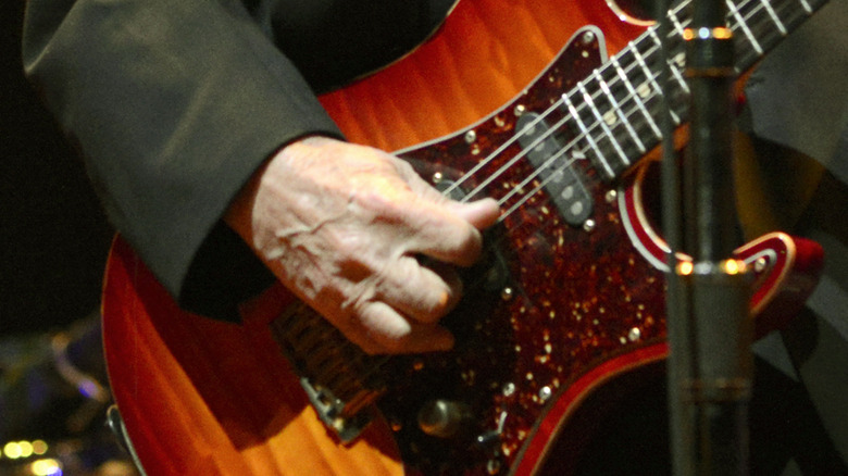 David Crosby's hand on red guitar