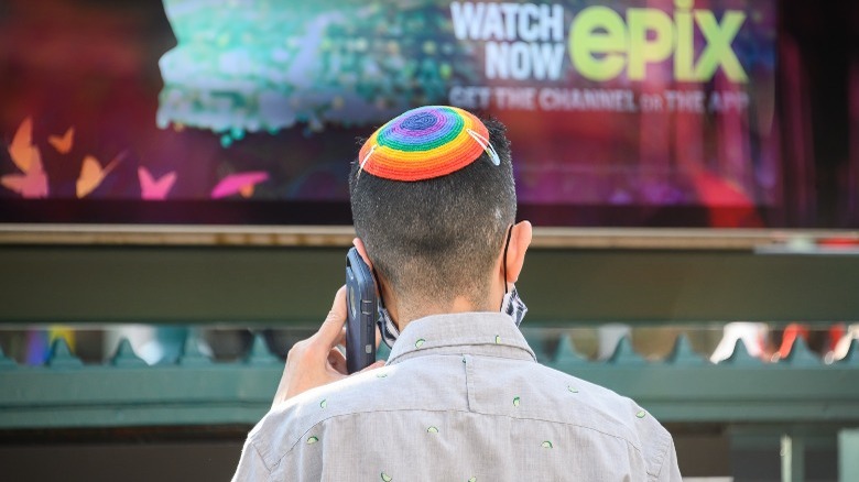 man wearing rainbow yarmulke