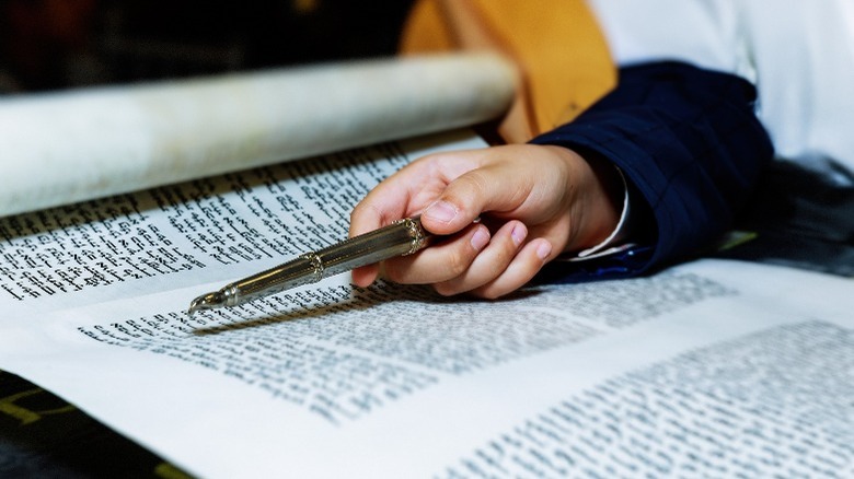 Torah scroll and hand pointing