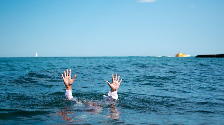 Man underwater with hands in air