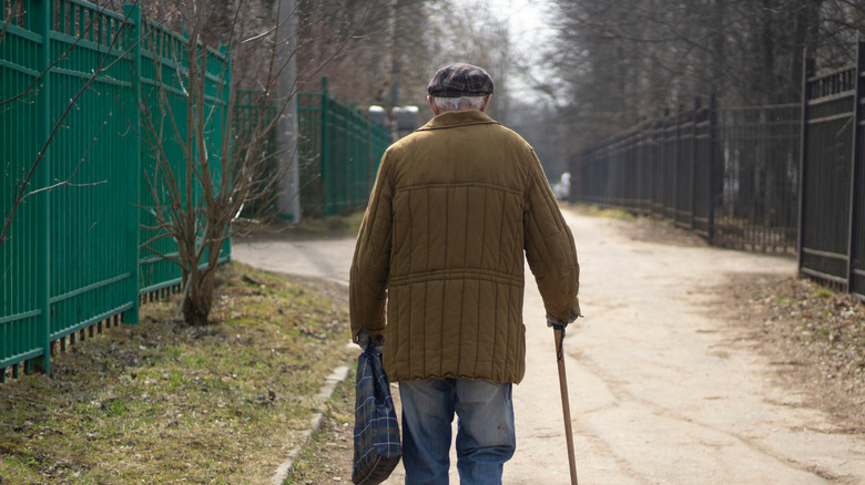 Old man walks down a street