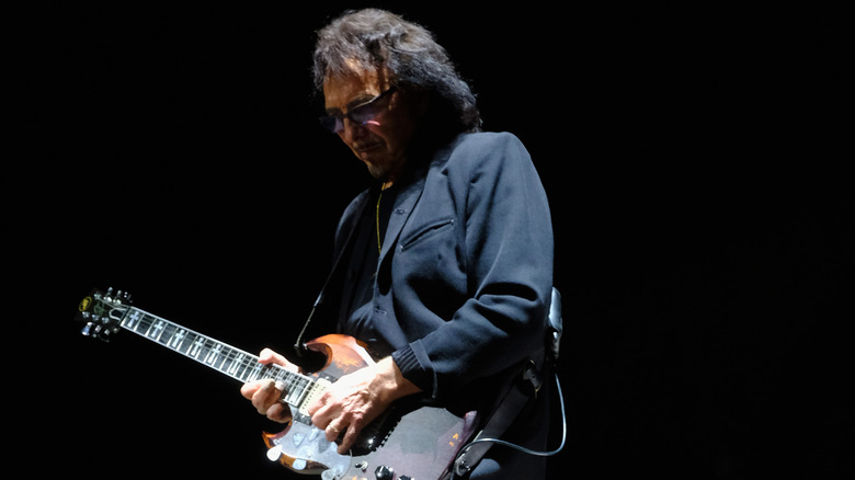 Tony Iommi sunglasses dark background playing guitar