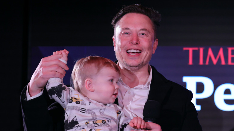 Elon Musk smiling with baby