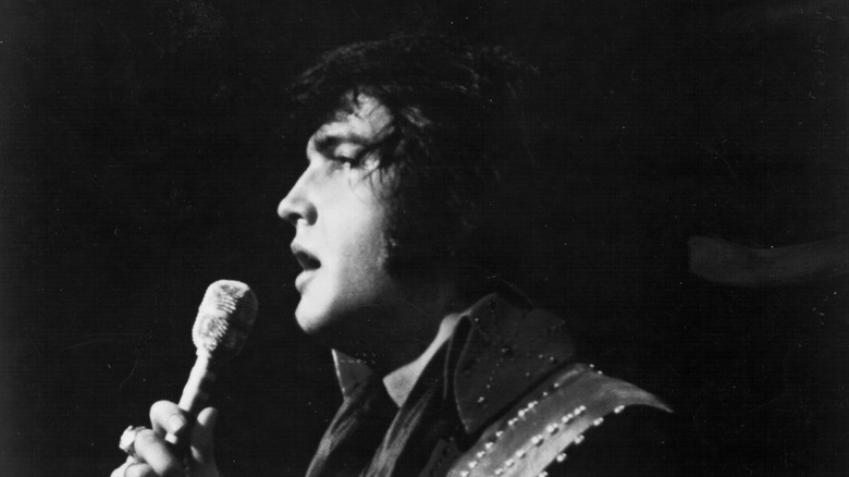 Elvis on stage with mic in jeweled outfit 