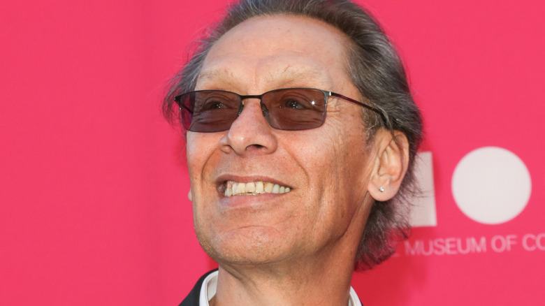 alex van halen in sunglasses looking up and smiling