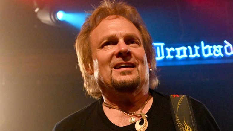 michael anthony playing bass onstage and grimacing