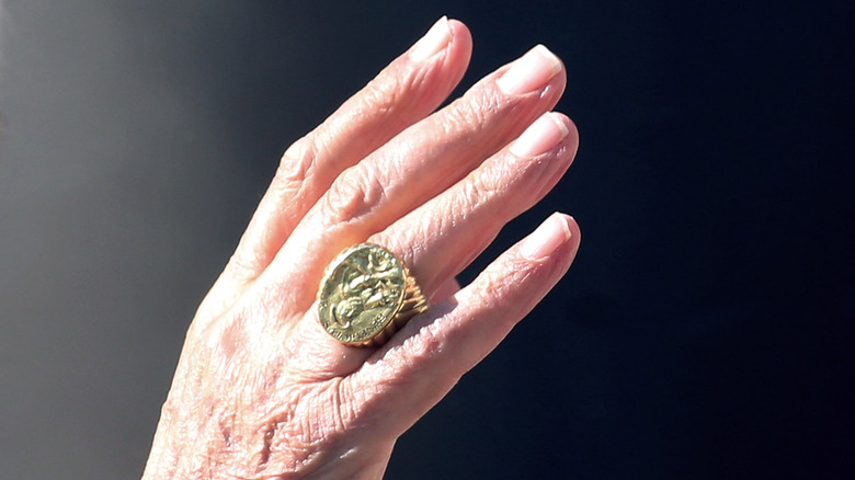 Waving hand with large gold ring