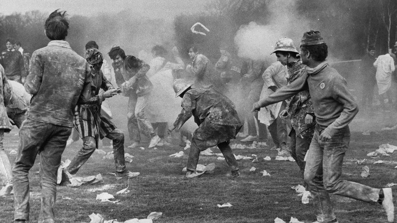 Students throwing flour at each other during university Rag Day in 1965, black and white