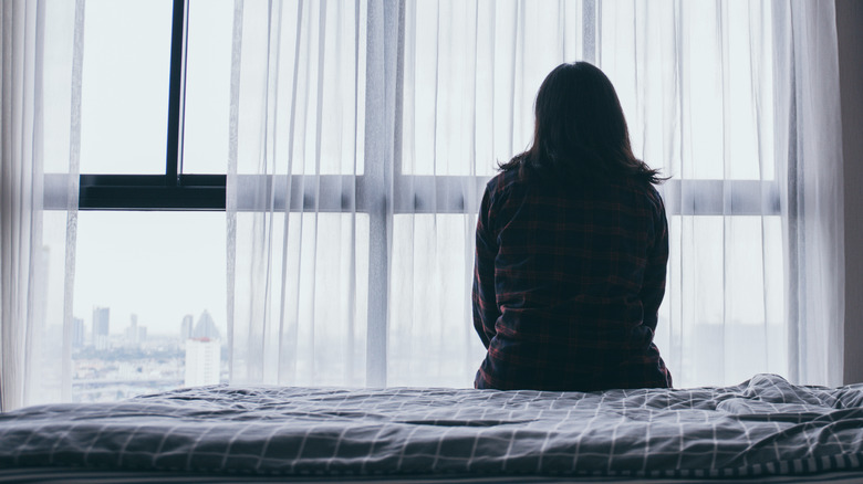 Depressed woman looking out window