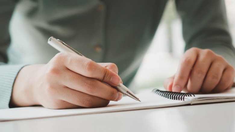 woman writing on paper