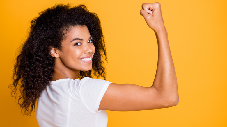 Woman smiling and flexing her bicep