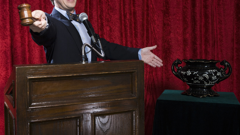 Auctioneer gesturing towards ornate vase