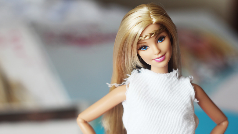 A Barbie doll in a white tank top with styled hair