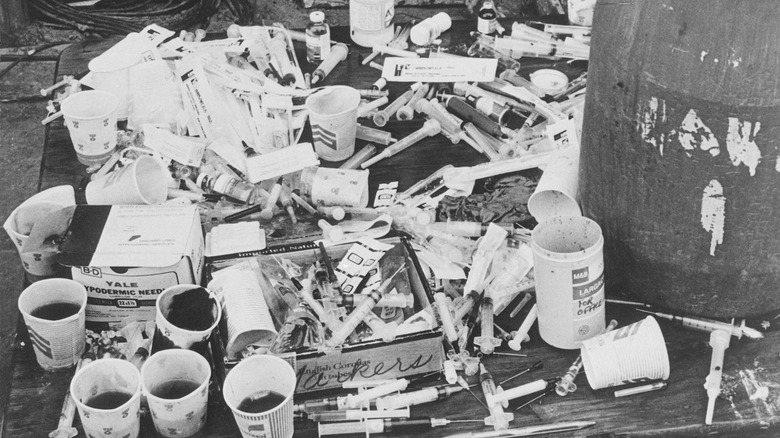 black and white image of paper cups and syringes found at Jonestown