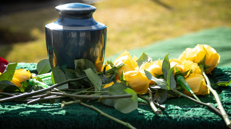 Metal funeral urn with yellow roses