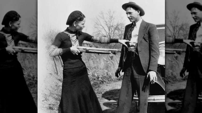 Bonnie in dress pointing shotgun at Clyde in suit