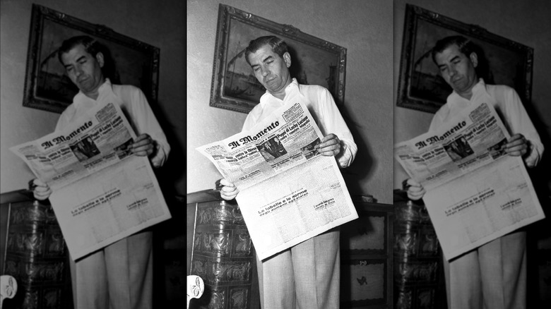 Salvatore Lucania standing reading newspaper