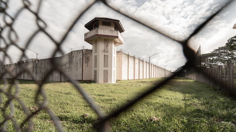 Prison tower behind chain-linkl fence