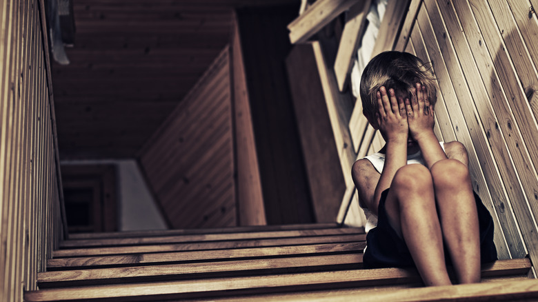 Child victim crying on stairs