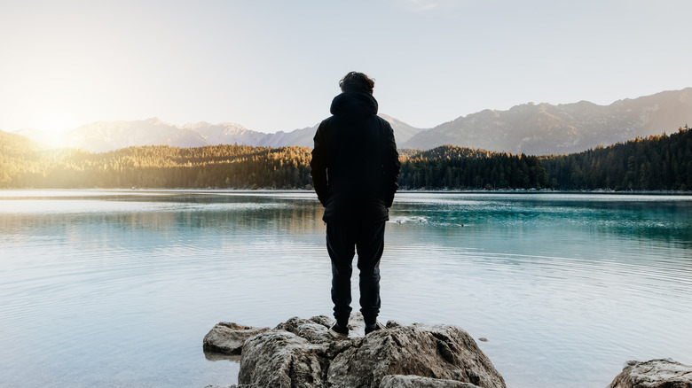 Silhouette of person in front of lake