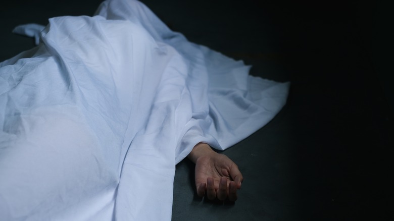 Dead body under white sheet