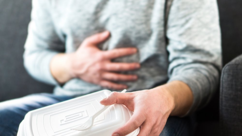 Man clutching stomach after eating too much