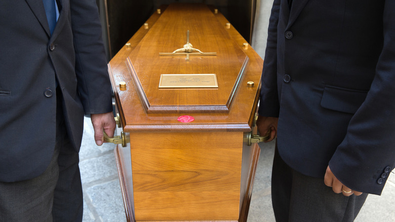 Guys holding coffin during funeral