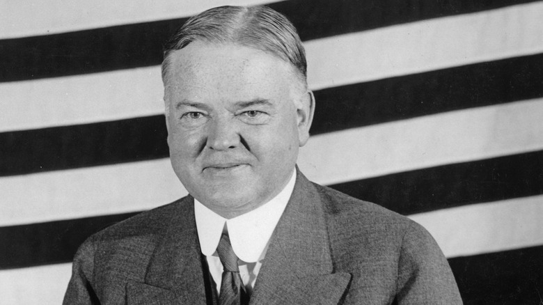 Hoover stands before American flag