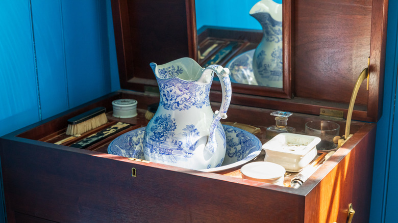 Vanity table with pitcher, water basin, mirror and grooming accessories 