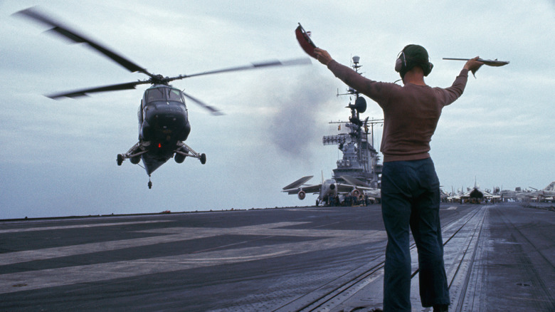 Aircraft marshaller guiding helicopter