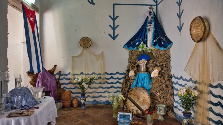 Santeria altar table and offerings cuban flag statue