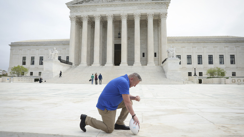 Joe Kennedy kneeling with football