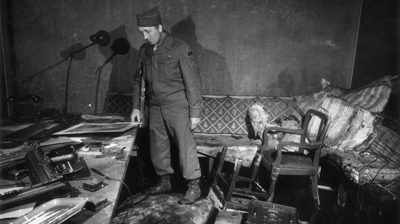 Private First Class Richard Blust surveys Hitler bunker damaged by fire.