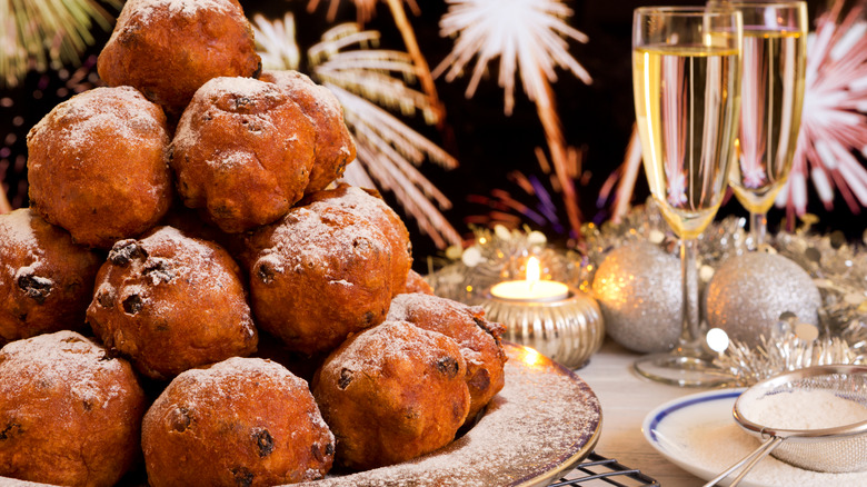 Oliebollen stacked on table next to champagne