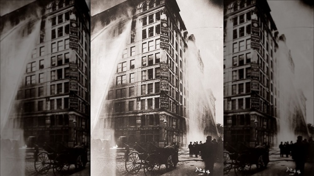 Fire hoses spray water on the upper floors of the Asch Building (housing the Triangle Shirtwaist Company) on Washington and Greene Streets, during the fire in New York City, March 25, 1911