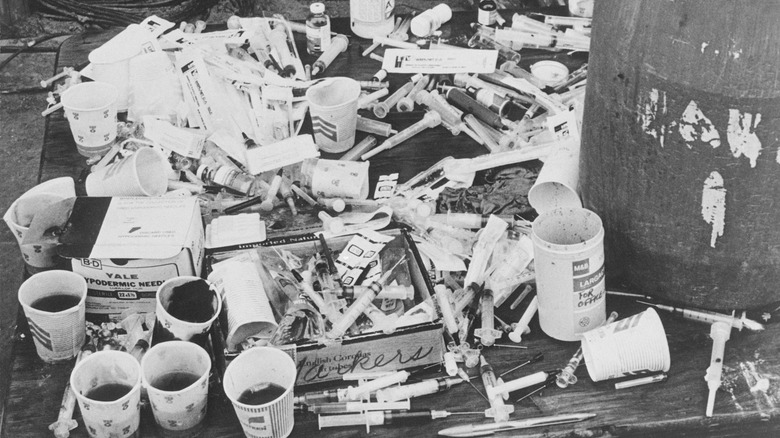 A table covered in syringes and cups at Jonestown