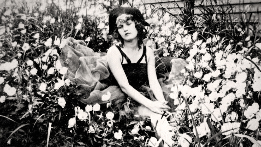 Zelda Fitzgerald sitting in a flowerbed