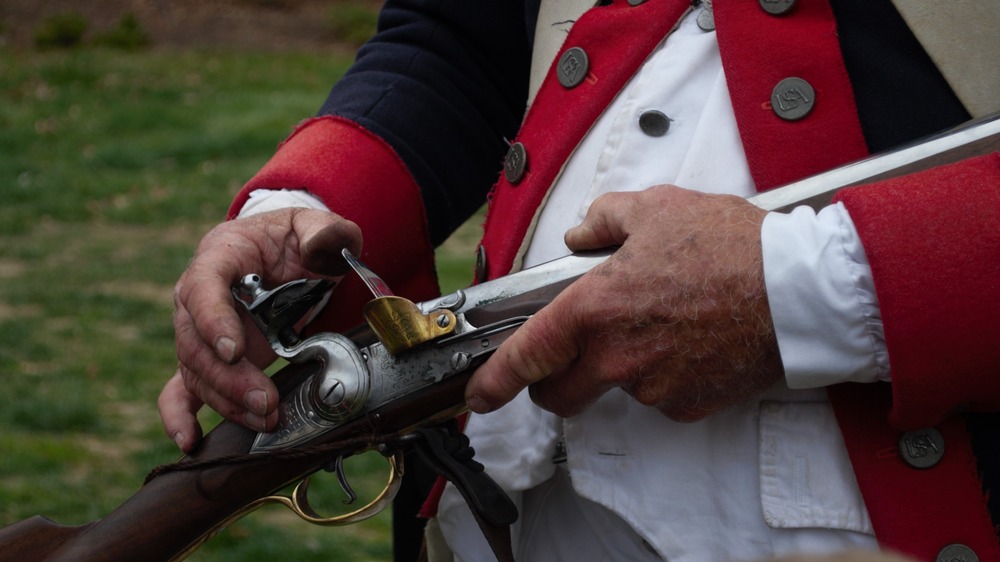 Man in calvary uniform loads his musket