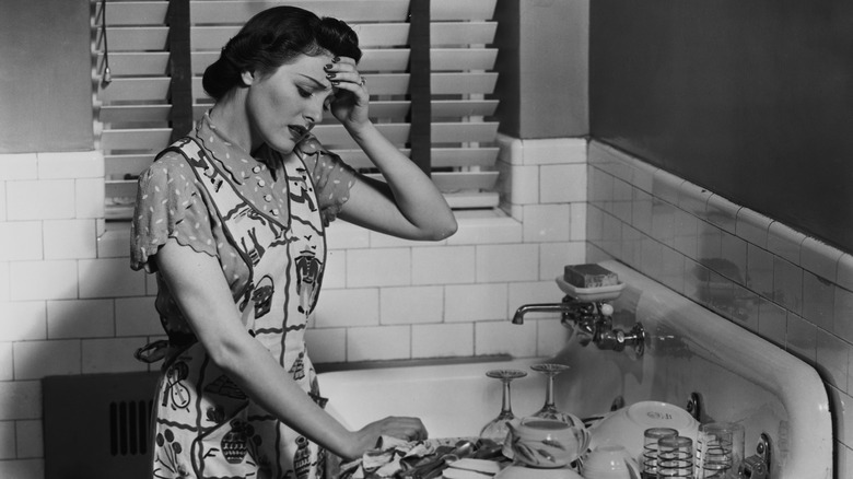 Woman in kitchen hand to forehead 1955