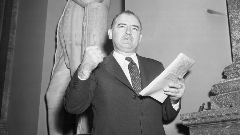 Joseph McCarthy raises clenched fist