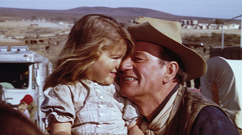 Cowboy john wayne smiling hugging girl on-set