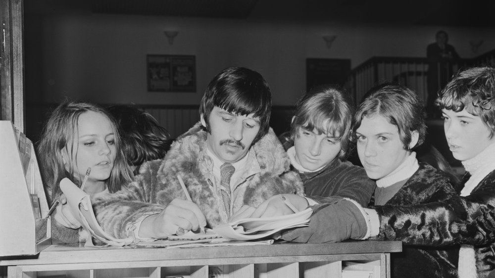 Ringo Starr signing autographs for fans at London Heathrow