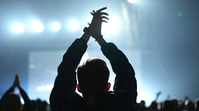 male silhouette clapping at concert