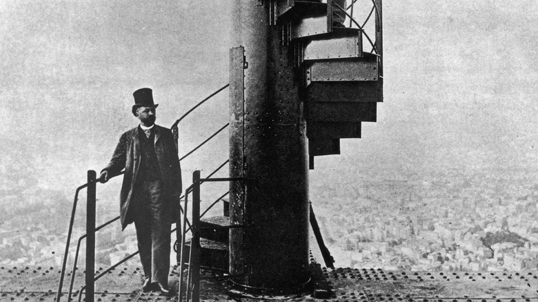 French engineer Alexandre Gustave Eiffel (1832 - 1923), left, poses high on the steps of the completed Eiffel Tower, which he designed for the 1889 Paris Exposition