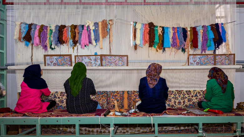 Iranian women weaving rugs