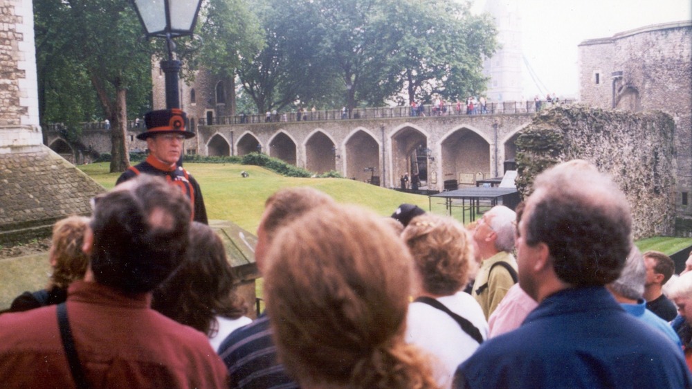 beefeater tour guide outside with group of people