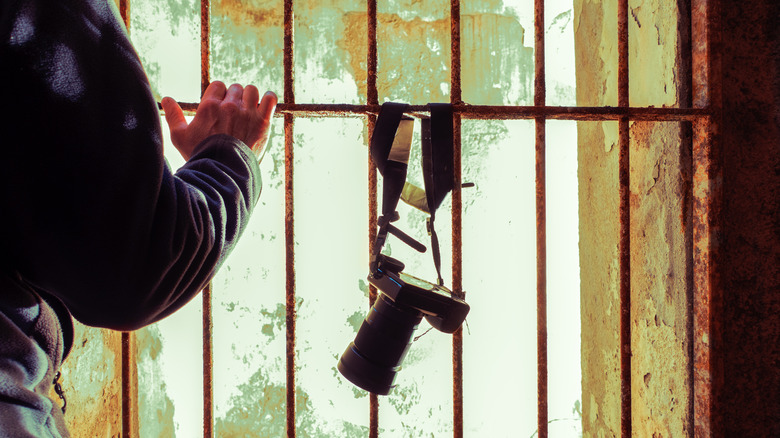 Photo reporter in a old rusty prison