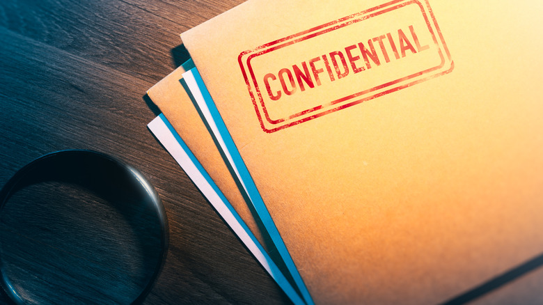 Confidential paperwork on private investigator's desk 