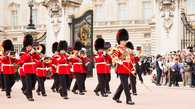 Guardsmen in red uniforms marching playing instruments