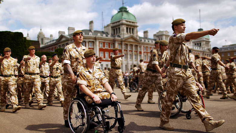 Wounded guardsmen in wheelchairs leading march
